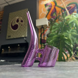 Pink custom puffco proxy replacement glass in front of plants