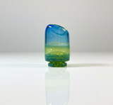 Green / blue puffco pivot glass mouthpiece on a white / neutral backround