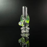 Clear puffco pivot glass mouthpiece with opal and green horns, against a black backround