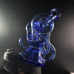 Blue recycler glass sitting fit on a puffco peak - black backround